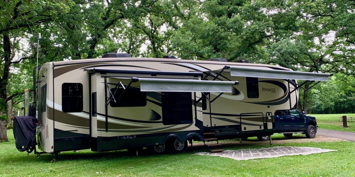 jayco pinnacle FBTS at campsite under trees with awnings out.