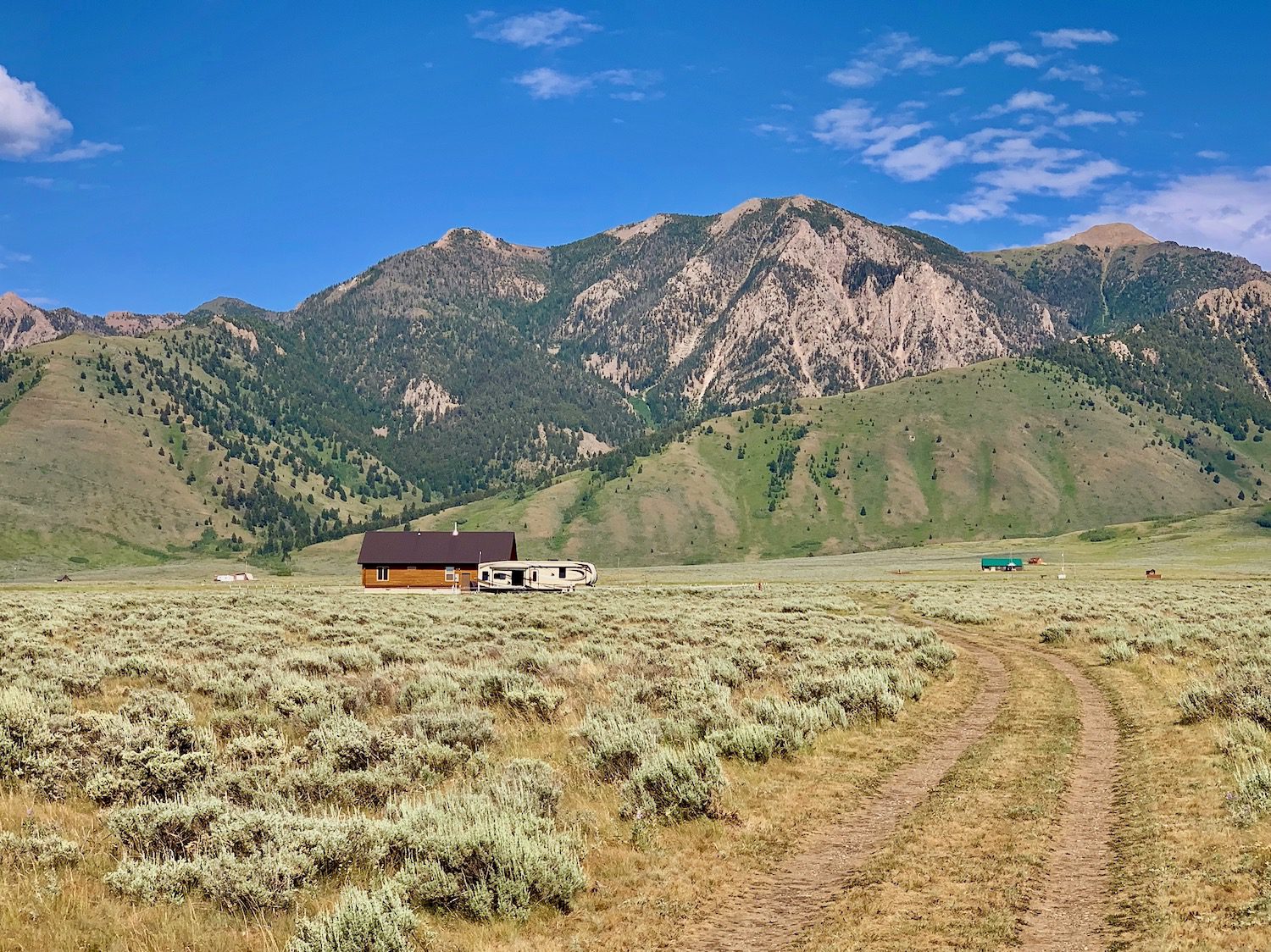living in an RV parked in field beside a cabin in Montana with amazing 360 degree mountain views.