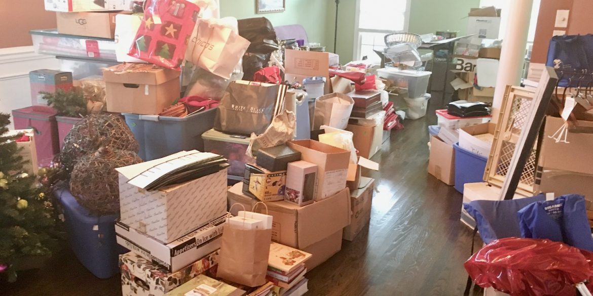 two rooms full of overflowing boxes and miscellaneous household items illustrating owning too much stuff